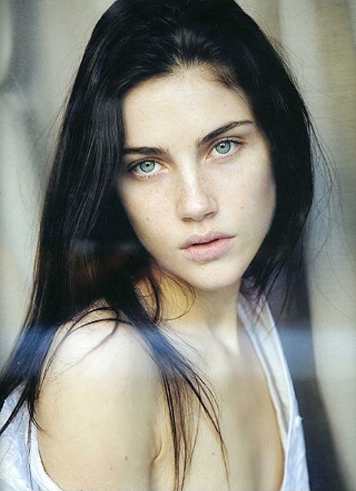 a woman with long dark hair and blue eyes