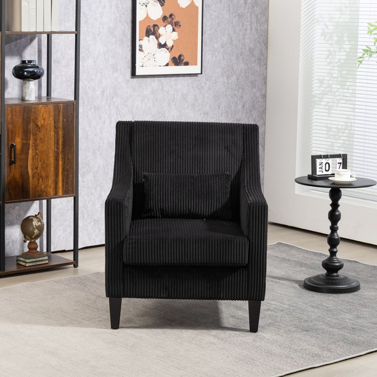 a black chair sitting on top of a rug in a living room