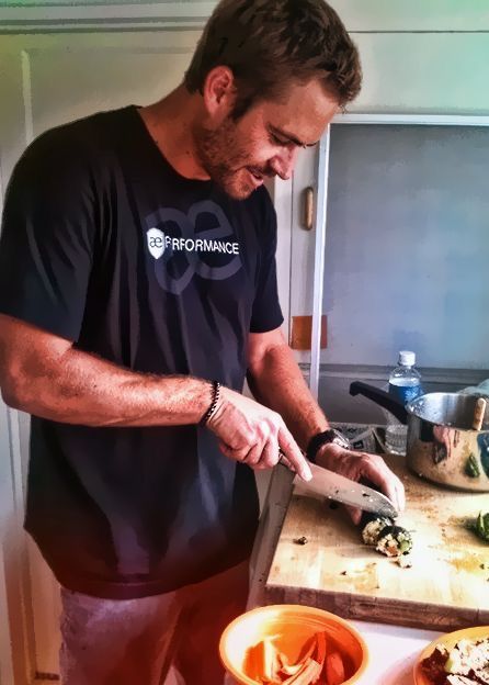 a man cutting up food on top of a wooden cutting board next to a bowl