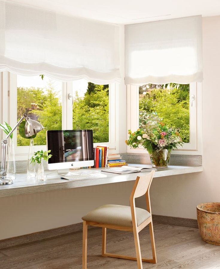 a home office with two windows and a desk in front of the window is shown