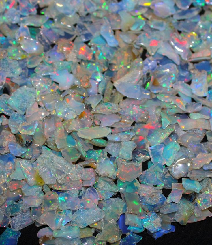 white opalite chips are scattered on a black surface