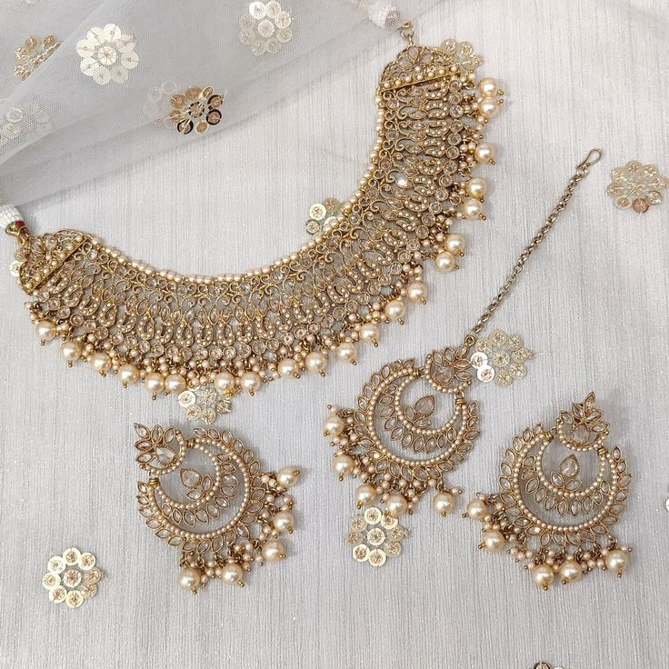 the necklace and earrings are adorned with pearls