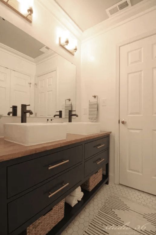 a bathroom with double sinks and two mirrors