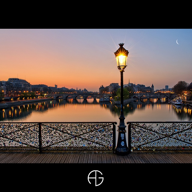 a street light sitting on the side of a bridge next to a body of water