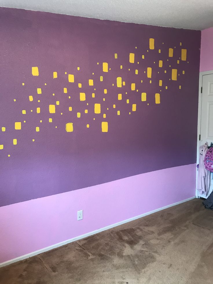 a room with purple walls and yellow squares painted on it's wall, next to a white door