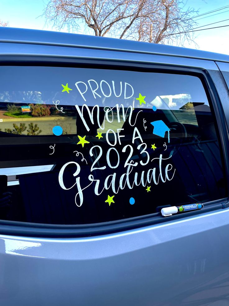 the back window of a car that says proud mom of a graduate with stars and confetti on it