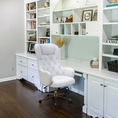 a white office chair sitting in front of a desk with bookshelves on it