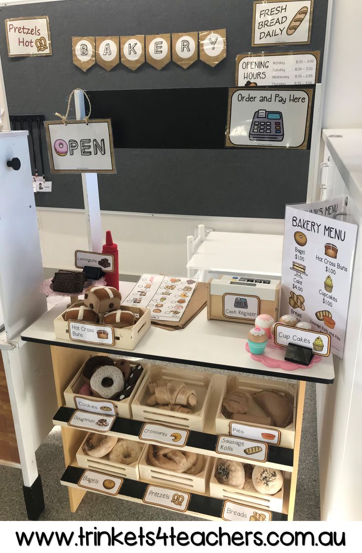 there is a display with donuts and other items on the table in front of it