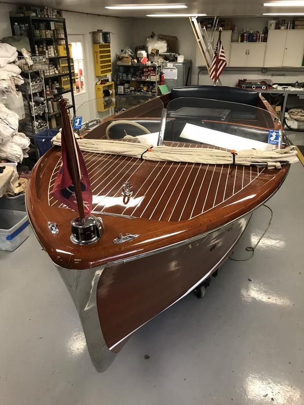 a wooden sailboat in a shop with an american flag on the front and side