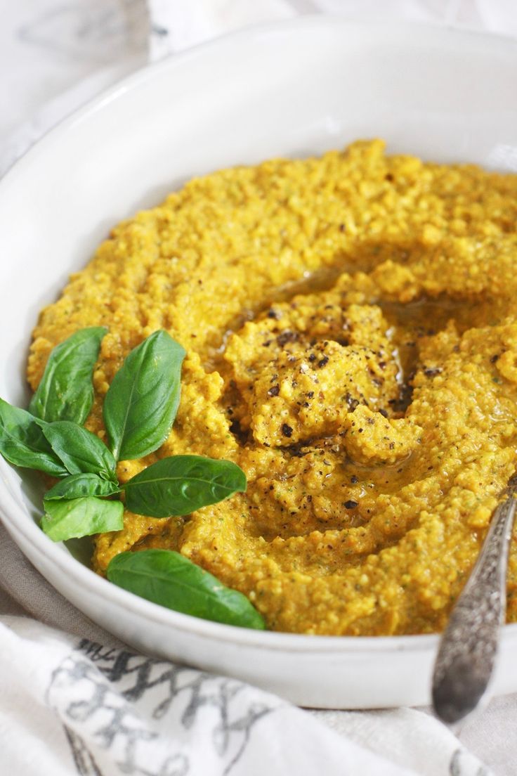 a white bowl filled with hummus and greens