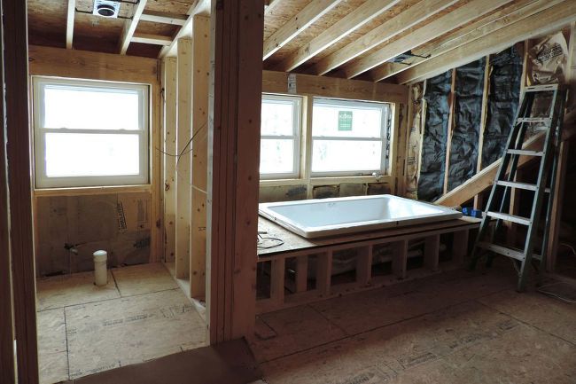 an unfinished bathroom with a tub and ladders in the room that is under construction