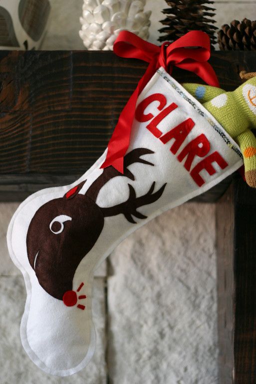 a christmas stocking hanging from the side of a fireplace with a reindeer on it