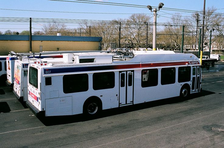 a white bus is parked on the side of the road