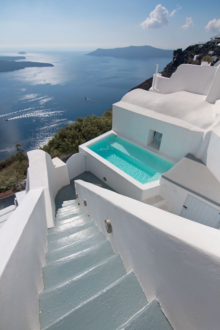 an outdoor swimming pool on the side of a building with stairs leading up to it