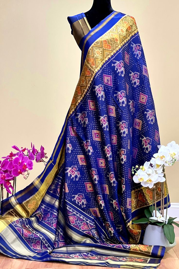 This beautiful single ikkat Patola saree in navy blue color is woven in narikunj design. The borders are woven in antique gold tissue with the ikkat design, and the pallu has a beautiful floral patterns. Approximate Length 6.5 mtrs (inclusive of blouse length)Height - 46 - 50" Saree comes with fall, picot and tassels done. Blouse piece is cut. Approximate weight - 1.2 lbs Kindly Note : The colors you see on your device may vary due to the color reproduction, brightness and resolution of individual devices. If you'd like more clarity before your purchase, please contact our support team. Blue Slub Silk Dupatta, Blue Slub Silk Dupatta For Transitional Season, Transitional Season Blue Slub Silk Dupatta, Indigo Traditional Drape For Navratri, Indigo Traditional Wear With Dupatta, Indigo Traditional Wear With Dupatta For Diwali, Unstitched Indigo Traditional Wear For Festivals, Blue Slub Silk Saree With Zari Work, Indigo Dupatta With Pallu For Wedding