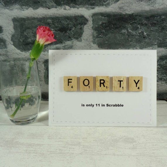 a card with scrabble letters and a rose in a vase