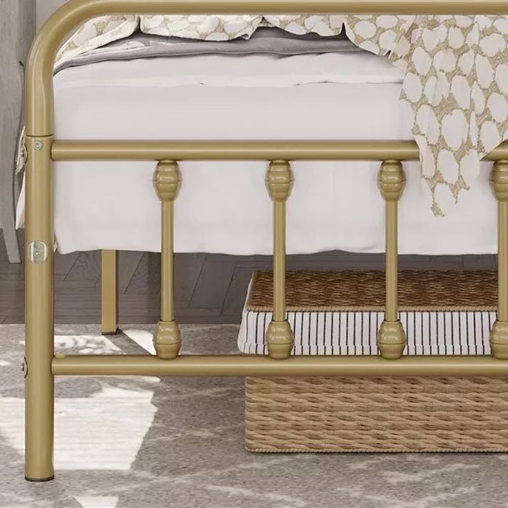 a gold metal bed frame with white sheets and pillows