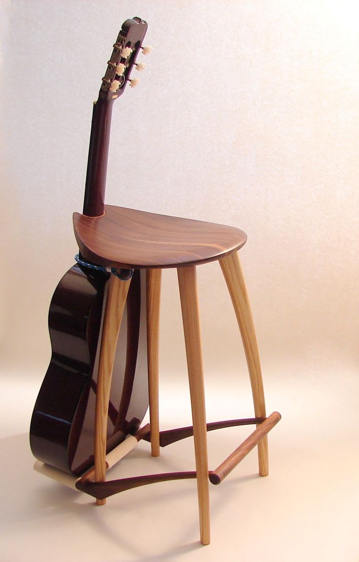 a guitar sitting on top of a wooden stool