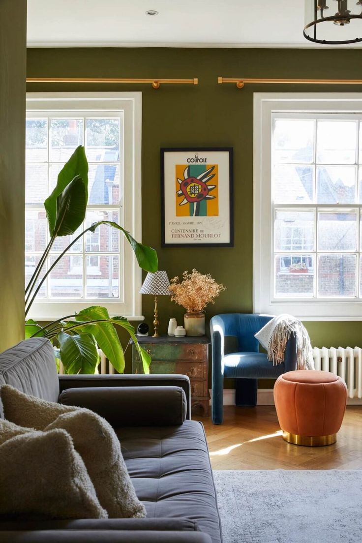 a living room filled with furniture and lots of window sill space next to a painting on the wall