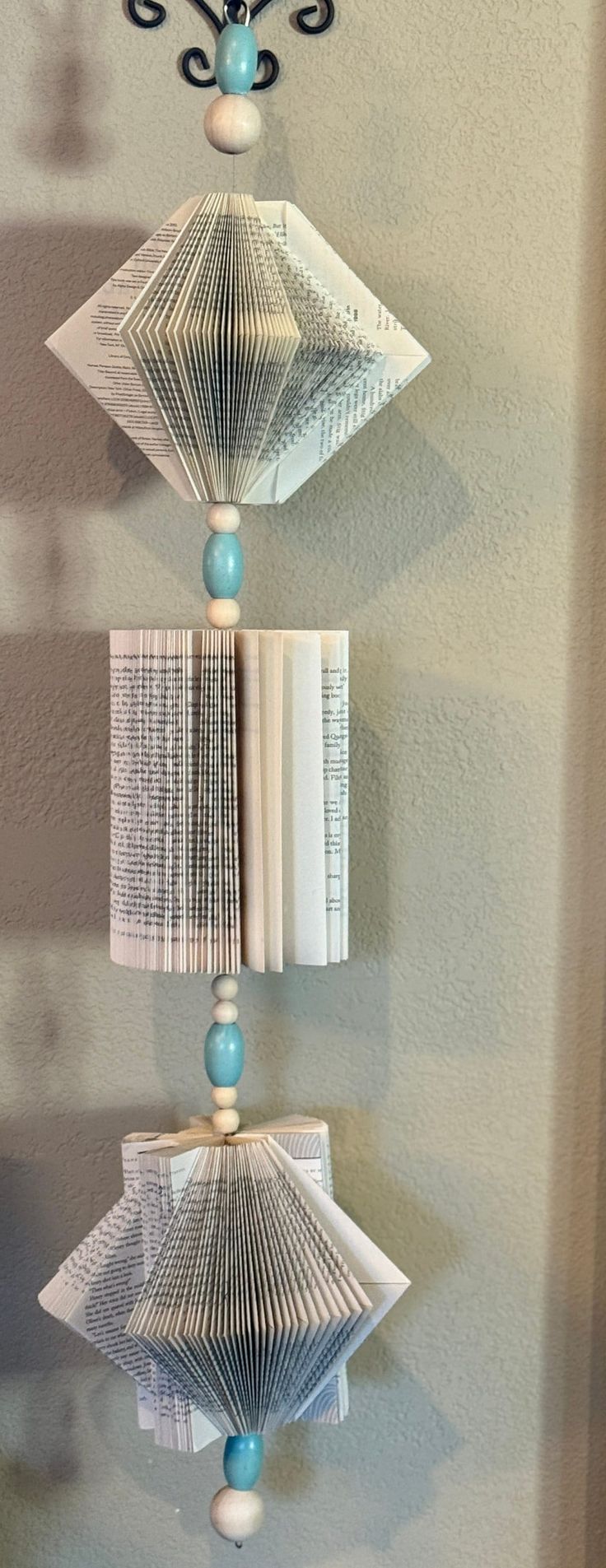 a clock made out of paper hanging from the side of a wall