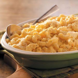 a green bowl filled with macaroni and cheese