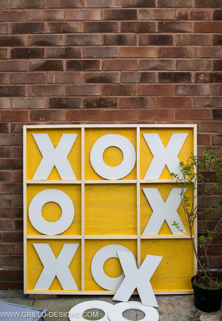 a yellow box with white letters on it next to a potted plant and scissors