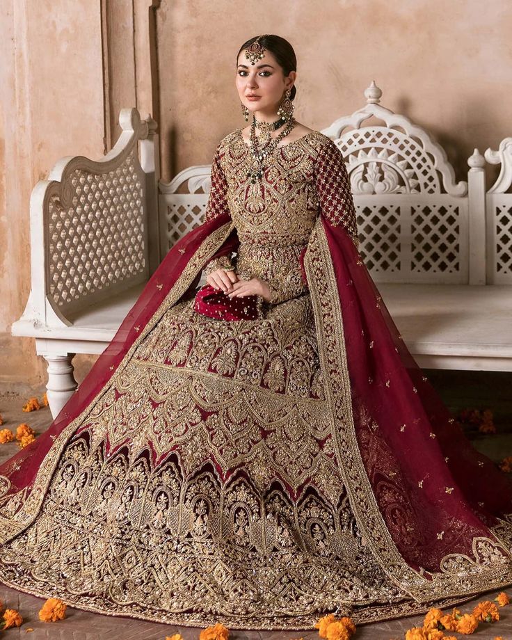 a woman in a bridal gown sitting on a bench