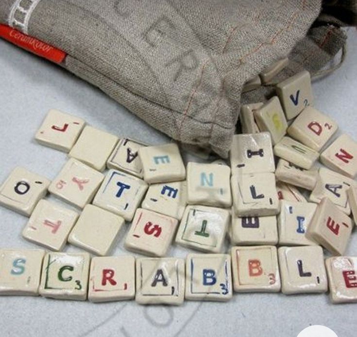 the letters are spelled in small blocks on the table next to a bag and pencil