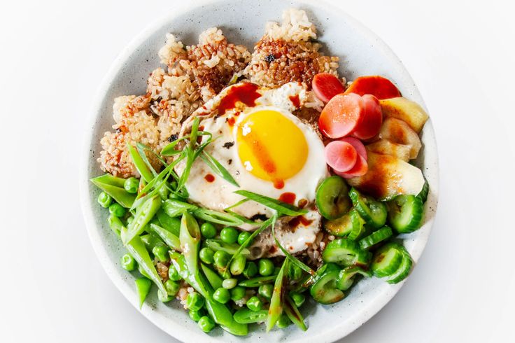 a white bowl filled with vegetables and an egg