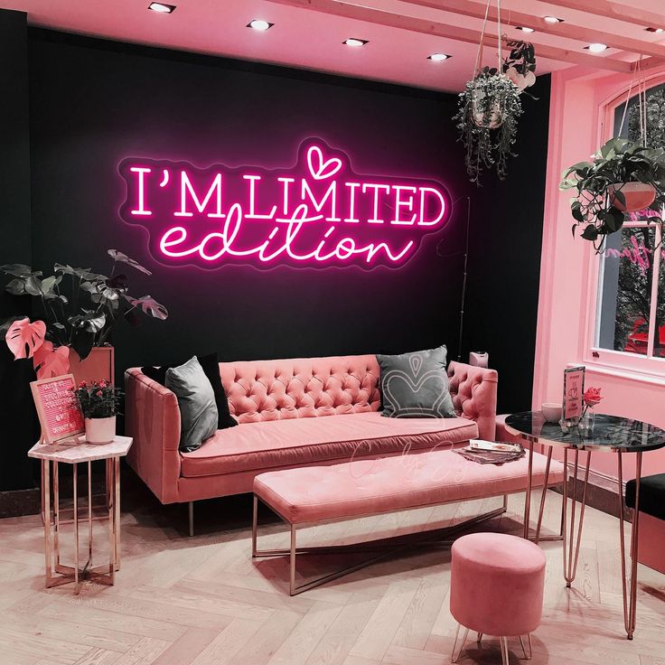 a living room with pink furniture and neon lights on the wall, along with an i'm limited sign