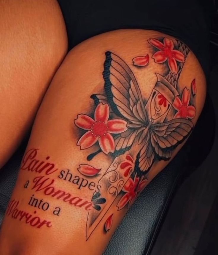 a woman's leg with tattoos and flowers on it, which has words written in red