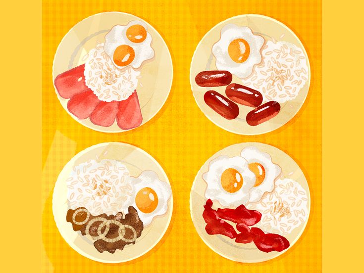 four plates with food on them sitting on a yellow tableclothed surface, including eggs, sausages and rice