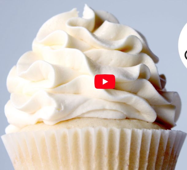 a cupcake with white frosting on top and a video play button above it