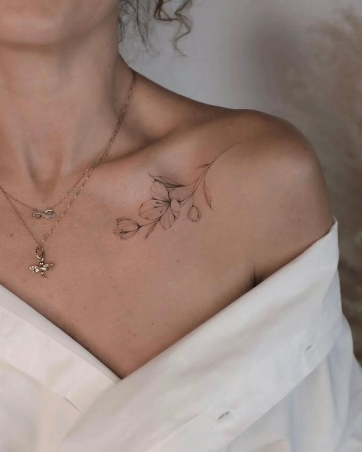 a woman wearing a white dress with tattoos on her chest