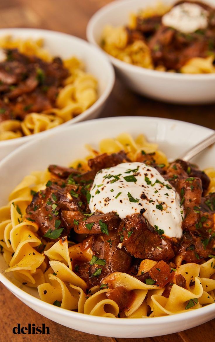 three bowls of pasta with meat and sauce on the top one bowl has sour cream