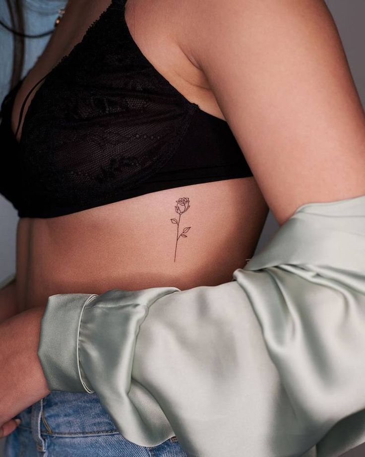 a woman's stomach with a flower tattoo on it