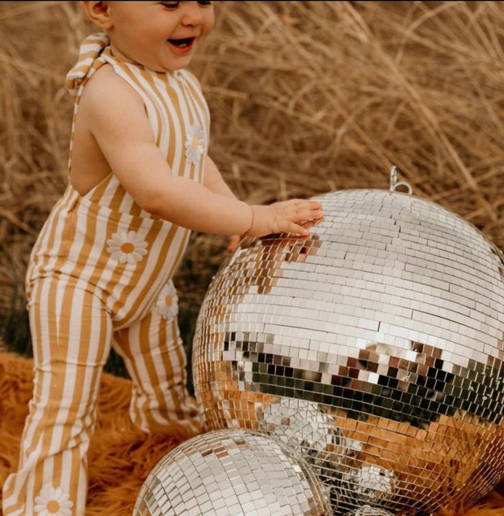 a little boy that is standing next to a disco ball