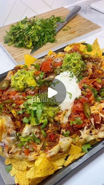 a platter filled with nachos and guacamole on top of a table