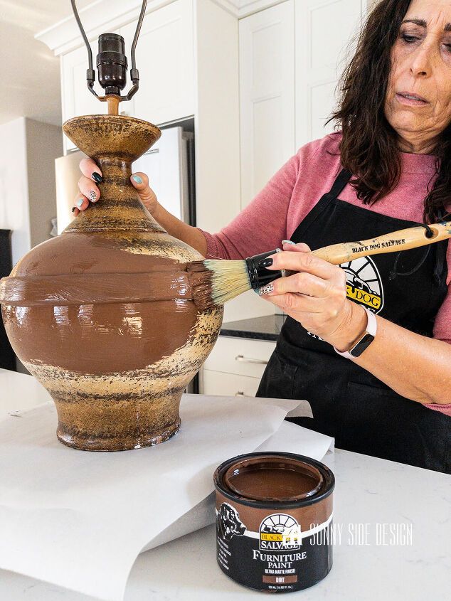 a woman is painting a vase with chocolate