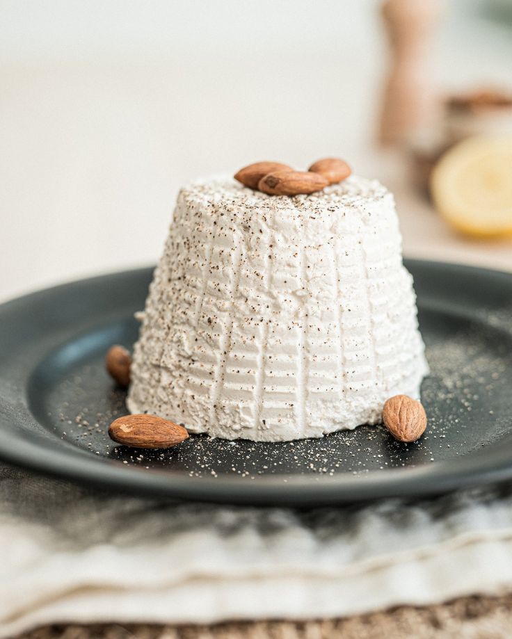 a cake with nuts on top is sitting on a plate