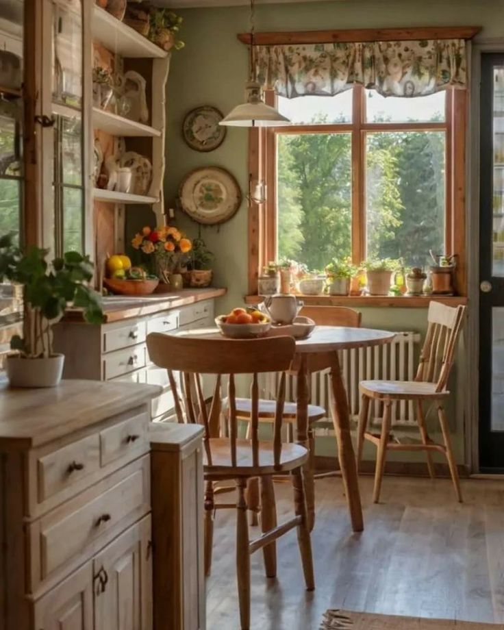 a dining room table and chairs in front of a kitchen window with open shelving