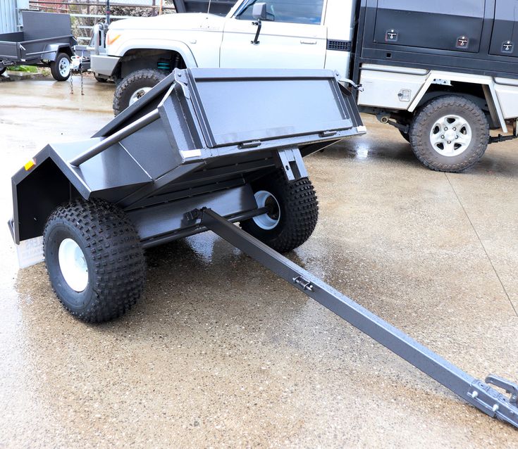 a black trailer with wheels on the ground