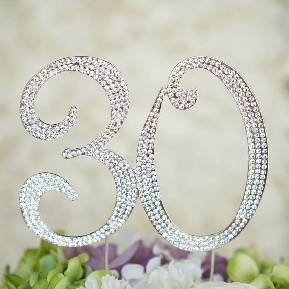 a cake topper that has the number thirty on it and is surrounded by flowers