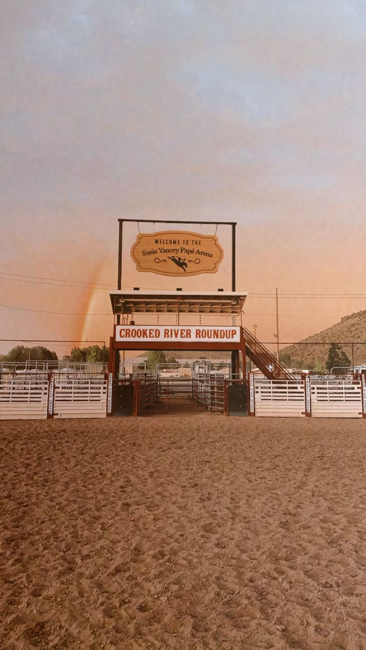 the entrance to crooked river roundup on a cloudy day with a rainbow in the background