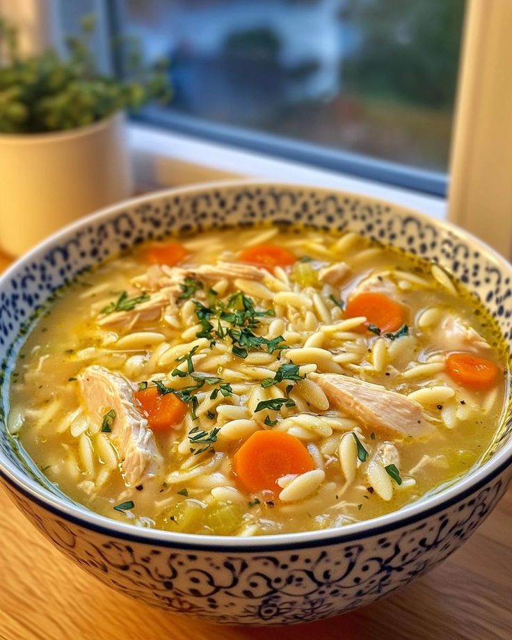 a bowl of chicken noodle soup on a table