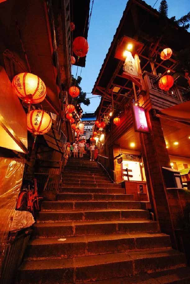 an alleyway with lanterns hanging from it's sides and stairs leading up to the second floor