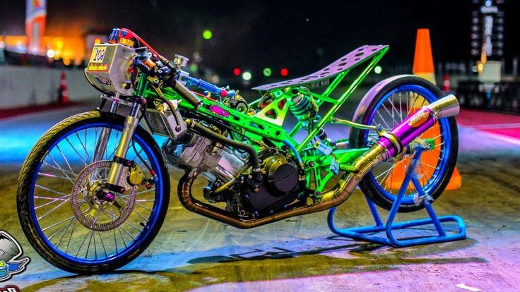 a green and blue motorcycle parked on top of a street