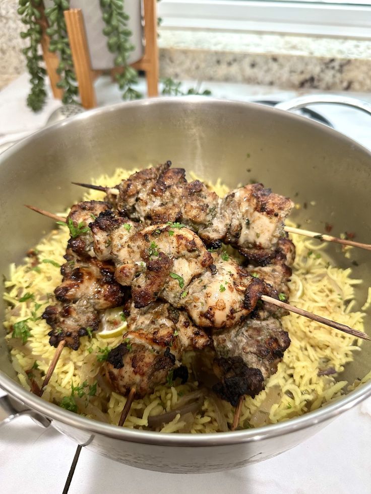 a pan filled with meat and rice on top of a table