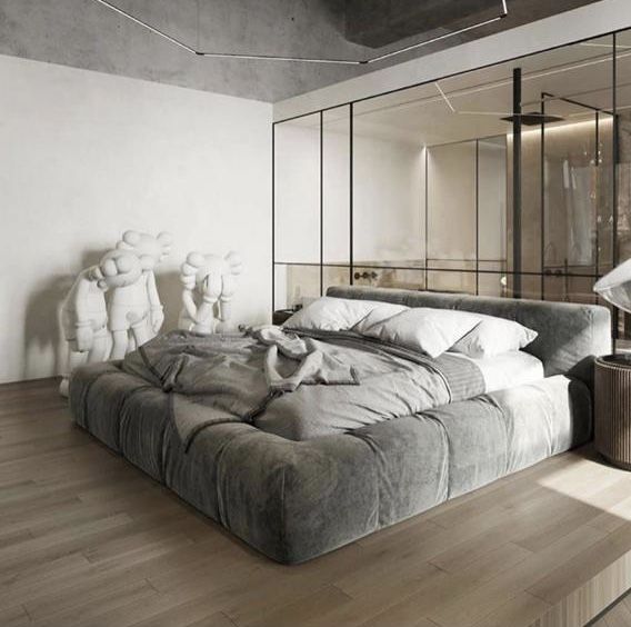 a large bed sitting on top of a hard wood floor next to a mirror wall