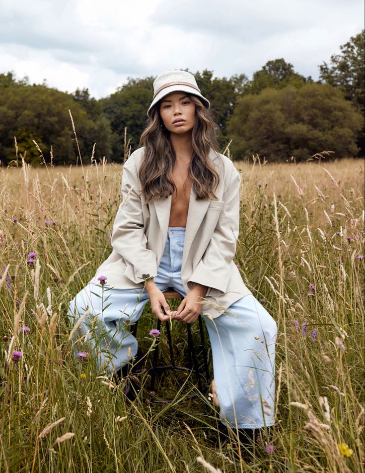 a woman sitting in the middle of a field